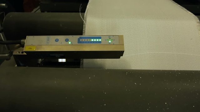 Scrolling synthetic fabric on the production tape with the help of shafts. Automated production.