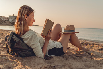 Frau allein am Meer liest ein Buch