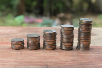 Stack of money coins arranged as a graph on wooden table