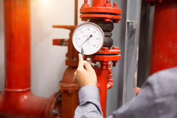 Engineer checking Condenser Water pump and pressure gauge , chiller water pump with pressure gauge.