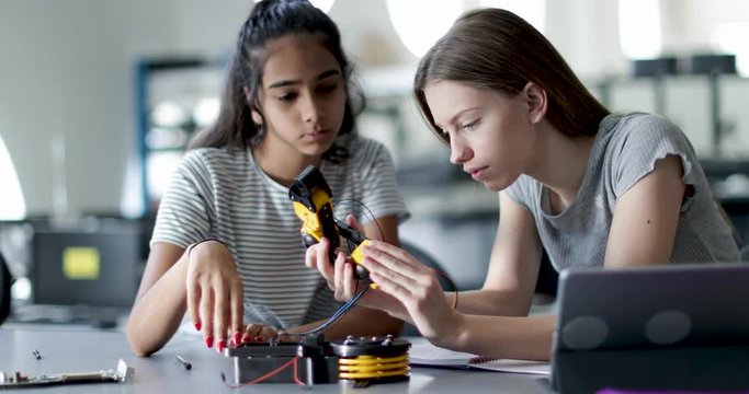 High school students working on a robotic arm in class