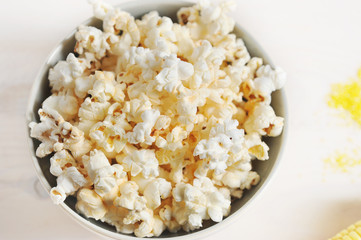 Popcorn in a round bowl. White background. Close-up. View from above. Macro photography.