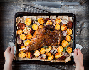 Juicy mutton scoop baked on a baking sheet with potatoes, onions, garlic and tomatoes