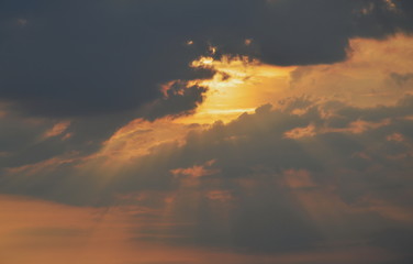 sunlight spreading through dark cloud in evening