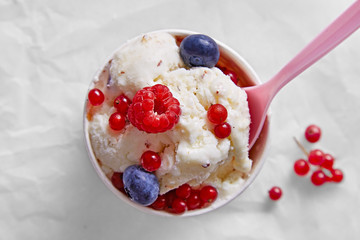 Ice cream sundae with fruits (raspberry, blueberry, red currant) in a bowl viewed from above on a marble background. Vanilla flavour. Top view