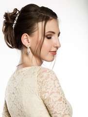 portrait of tender young woman in cream dress on a white background. professional make-up