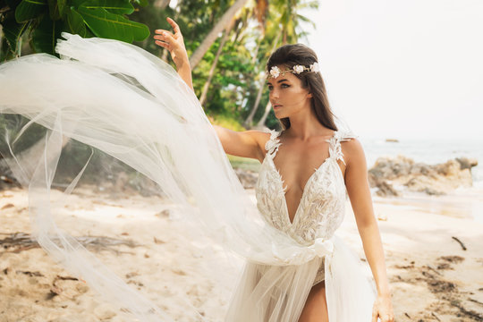 Sensual bride wearing beautiful wedding dress on the tropical island