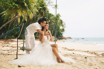 Happy young married couple celebrating their wedding on the beach