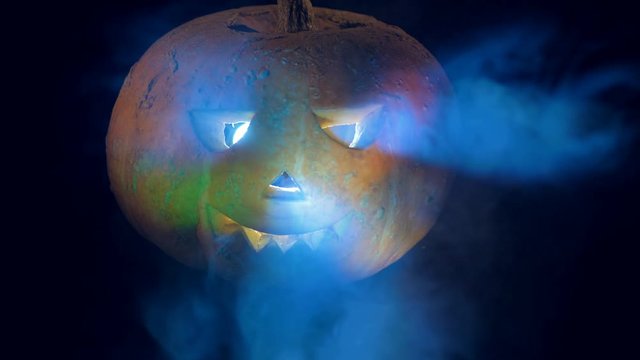 Colourful lights are flashing on the surface of a halloween pumpkin