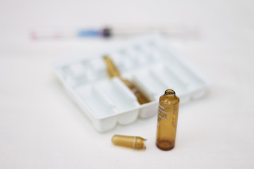 Empty medical ampoules infusion and used syringe after injection isolated on white background