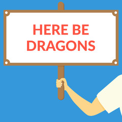 HERE BE DRAGONS. Hand holding wooden sign