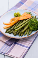 Fried asparagus with broccoli and lemon and carrot.