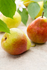 Fresh pears with leaves in a on wooden background.