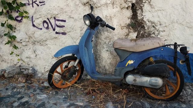 Old abandoned motorcycle lies on the streets of Granada, Spain.