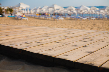 Lounge chairs with white umbrella on a beach in a sunny day.
