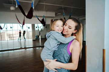 Mother holds her daughter in her arms