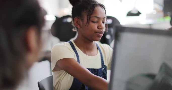 Closeup teenage girl using a computer in class