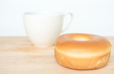 donut and cup cocoa drink on wooden table on white background.