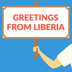 GREETINGS FROM LIBERIA. Hand holding wooden sign