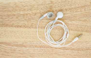 earbuds or earphones top view on wooden background