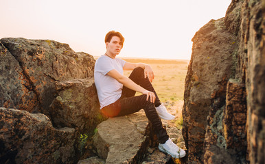 tourist and model at the top of the mountain enjoying the sunset over the tropical valley, posing in front of the camera