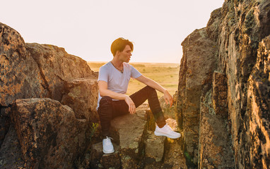 tourist and model at the top of the mountain enjoying the sunset over the tropical valley, posing in front of the camera