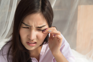 asian woman suffering from irritated eye; concept of optical health care, eye care, allergic or...