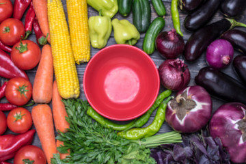 A table arrangement of a variety of fresh fruits and vegetables sorted by colors-pepper, tomato, corn, carrot, salad, cilantro, eggplant, cucumber, basil,dill,onion.Healthy food concept Space for text