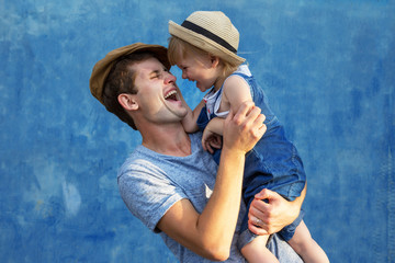 Father and doughter hugging on a blue background.