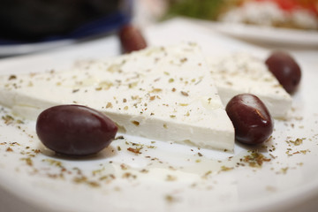 Fresh Feta cheese slices with black olives and oregano