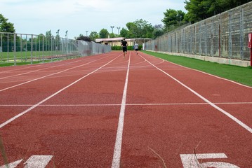Fototapeta premium People running in the tartan of an open stadium.