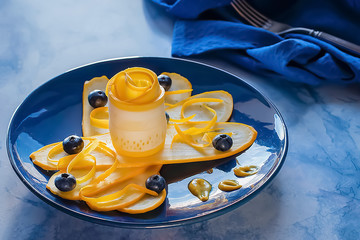 Salad of yellow zucchini and blueberries on a blue plate. Organic food. Concept of vegetarianism and raw food.