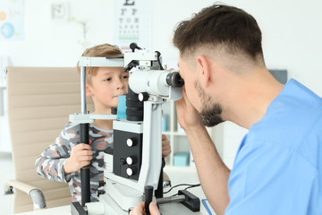 Ophthalmologist examining little boy in clinic