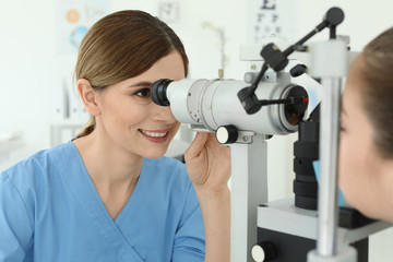 Ophthalmologist examining little girl in clinic