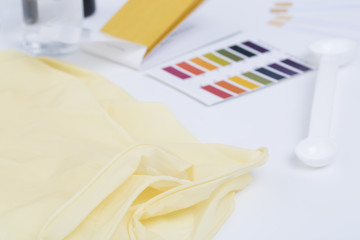 Cosmetic ingredients safety testing tools, pH value, water powder value, moisture degree, pH test paper, dropper, chemical solvent, and rubber gloves in white background