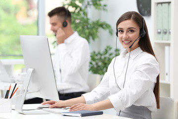 Female receptionist with headset at desk in office