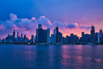 Fototapeta na wymiar Colorful sunset reflecting onto clouds, Lake Michigan, and Chicago skyline during summer recreation season.
