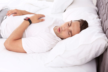 Fototapeta na wymiar Young man sleeping in bed at home