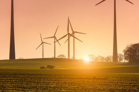 Windpark Winr&auml;der Wingeneratoren Landwirtschaft Landmaschine im Morgenlicht Tagesanbruch Sonnenaufgang Tagesbeginn Sonnenenergie gr&uuml;ne wirtschaft, &ouml;kologische Energiegewinnung sauberer Strom Windkraft