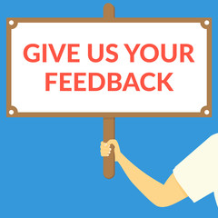 GIVE US YOUR FEEDBACK. Hand holding wooden sign