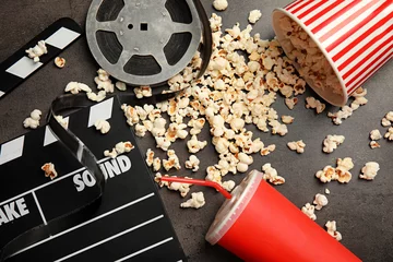 Poster Flache Laienkomposition mit Popcorn, Filmrolle und Filmklappe auf grauem Hintergrund © New Africa