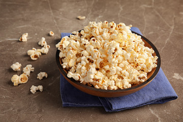 Bowl of tasty popcorn on grey background