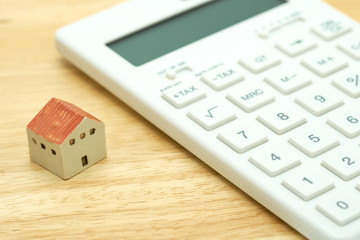 A model house model is placed on a calculator. as background property real estate concept with copy space for your text or  design.