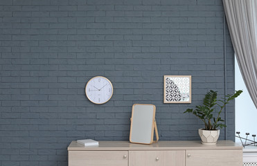 Stylish clock hanging on wall in room. Time of day