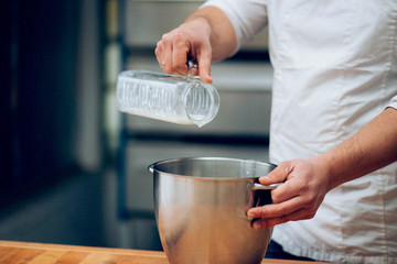 Male hands of the chef with a dish and milk