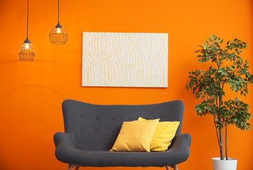 Modern living room interior with comfortable gray sofa near color wall