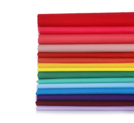 Pile of colorful t-shirts on white background