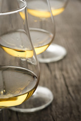 Whiskey im Glas auf Holz als Nahaufnahme im Hochformat