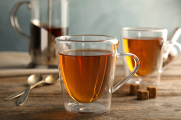 Glass cups with black tea on wooden table