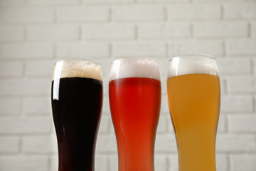 Glasses with different types of cold tasty beer on blurred background